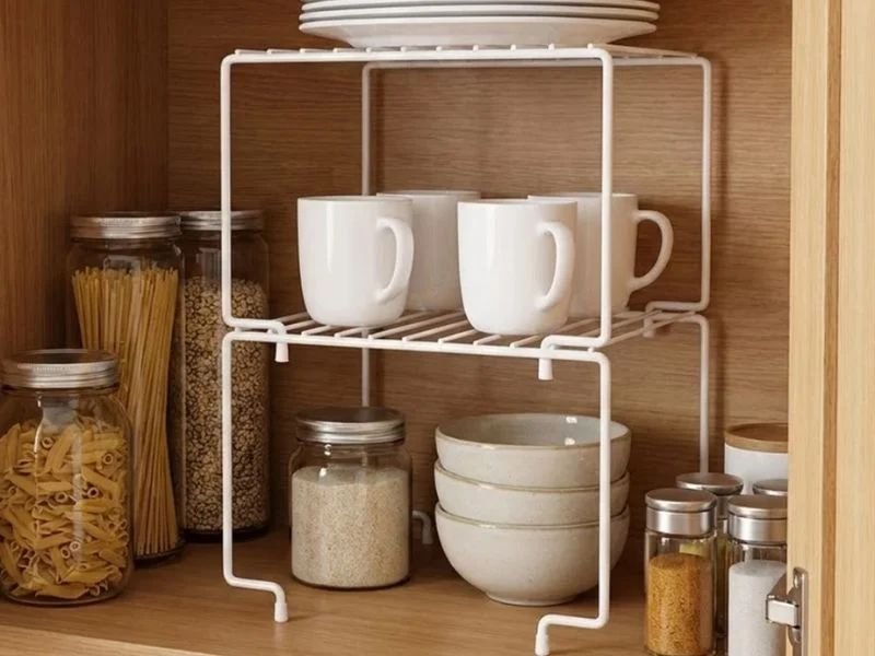 Prateleira organizadora empilhável criando níveis extras no armário de cozinha